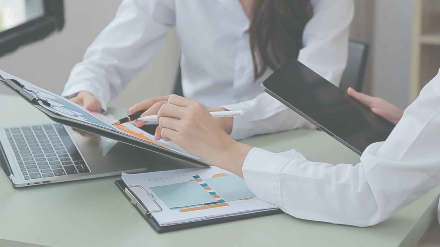 Working desk setup showing journalism materials and research notes spread across a workspace in Kota Kinabalu